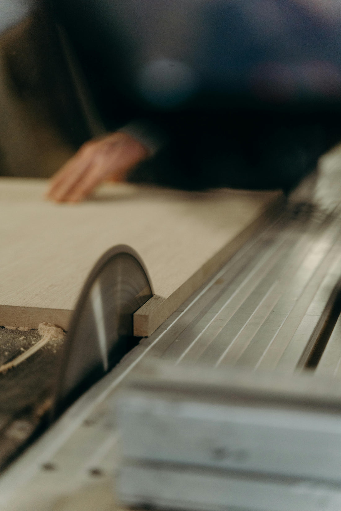 Carpenter using a table saw to shape wood for furniture production