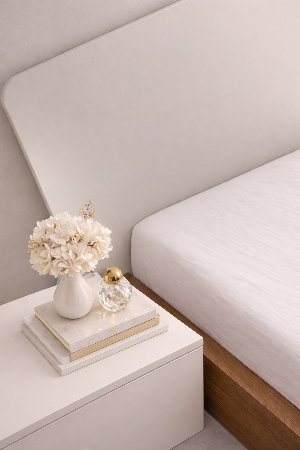 bedside-table-styling-modern-bedroom-detail
white-nightstand-decor-with-flowers-and-books
minimal-bedroom-bedside-detail-shot