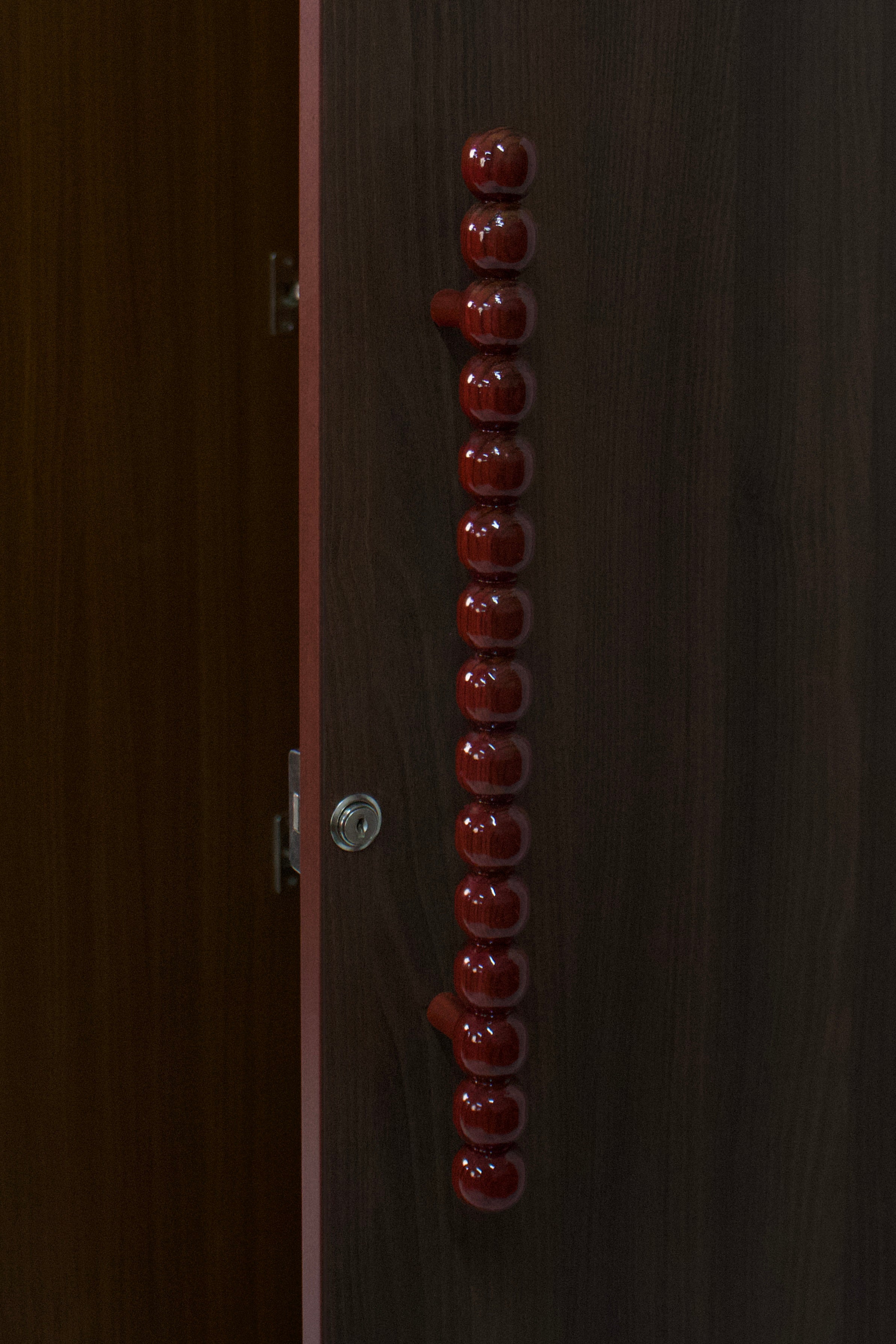 decorative-red-handles-wooden-wardrobe-closeup
unique-wardrobe-handle-design-modern-furniture
risa-signature-handle-detail-wardrobe